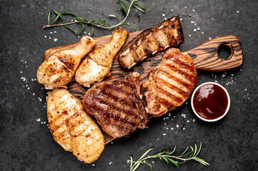 Various types of grilled meat, beef, pork, chicken on stone background	