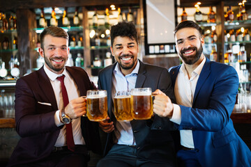 People, men, leisure, friendship and celebration concept. Happy male friends drinking beer at pub