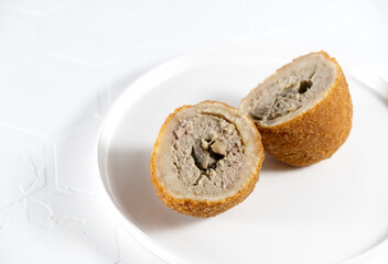 Chicken Kiev cutlet with mashed potatoes and slice on a plate, white background