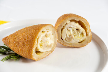 Chicken Kiev cutlet with mashed potatoes and slice on a plate, white background