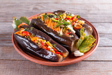 Pickled stuffed eggplant with vegetables in a plate on a table