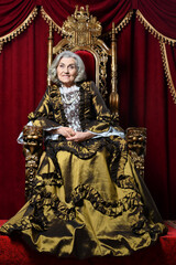 Fototapeta na wymiar Portrait of beautiful senior woman Queen on throne