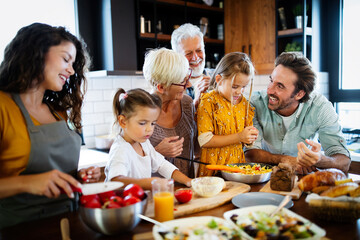 Grandparents, parents and children spending happy time in the kitchen