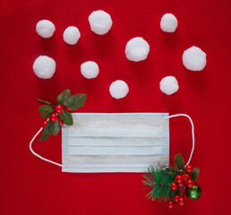 Christmas flat lay with disposable face mask and decorative snowballs and christmas decoration. Stay safe in New Year. Creative concept of Christmas and New Year in new reality