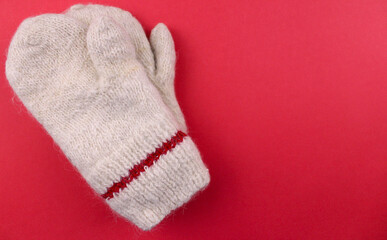 Fototapeta na wymiar Knitted warm mittens on a red background