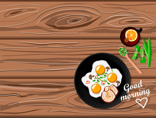 Fried eggs and bacon, citrus tea and pandan spices, top view on wooden table with good morning lettering. Home made breakfast with negative space