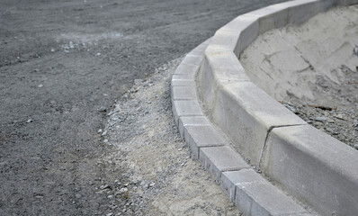 installation of concrete curb into concrete. in the space of the road, which so far has only a...