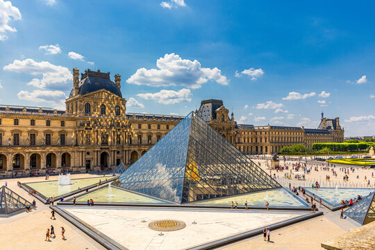 Paris, France - July 6, 2018: View of the Louvre Museum, the world's largest art museum and a historic monument in Paris, France, on a sunny day. Panoramic view of Louvre Museum and it's courtyard.
