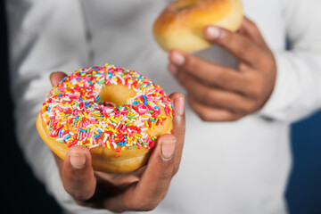 Close up of hand holding donuts .