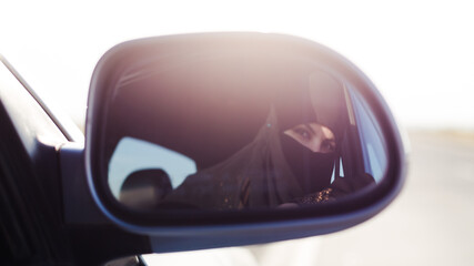Muslim driver in the reflection of the rearview mirror