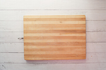 wooden chopping board on wooden background top down 