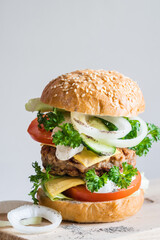 Delicious burger on grey background, selective focus, vertical orientation, close-up