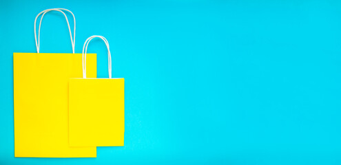 Yellow shopping bags over the blue background. Colorful flatly banner with space for text.