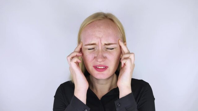 A woman holds his head with his hands. Sensation of headache, migraine and dizziness. Headaches from stress or overwork. On examination by a doctor.