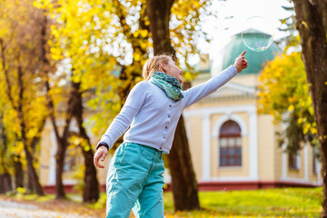 Adorable little girl blowing soap bubbles in european city. Happy kid enjoy summer vacation in Italy