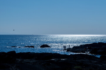 三浦半島・城ヶ島の風景　磯で遊ぶ人のシルエット　