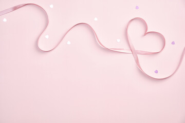 Happy Valentines day concept. Heart shaped ribbon and confetti on pink background. Flat lay, top...
