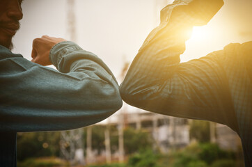 Close-up photo of two people hitting their elbows to avoid the outdoor coronavirus. Friends...