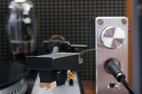 close-up of a turntable needle, vinyl records on the background of old equipment