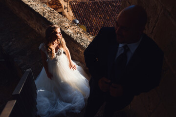 bride and groom pose looking to the side. Beautiful light and shadow