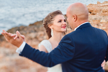 Obraz premium newlywed couple hugging on the seashore and rocks