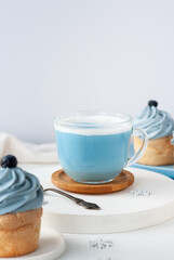 Blue trendy drink from Butterfly pea tea with milk and cake for breakfast