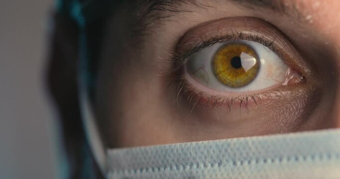 Occhio verde di un medico uomo con mascherina 