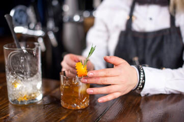 Focused barmaid formulates a cocktail in cocktail bars