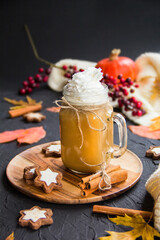 Pumpkin spiced latte or coffee in a cup on turquoise vintage background. Autumn, fall, or winter hot drink. Cozy breakfast or snack.