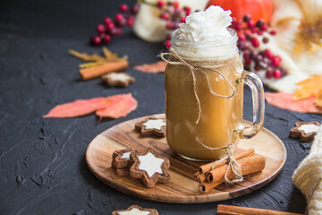 Pumpkin spiced latte or coffee in a cup on turquoise vintage background. Autumn, fall, or winter hot drink. Cozy breakfast or snack.