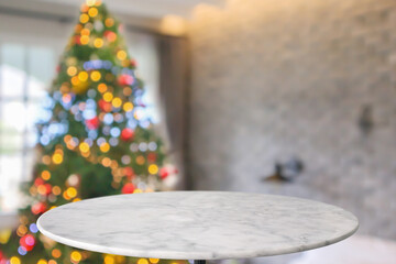 Empty round marble table top with blurred Christmas tree with bokeh light background