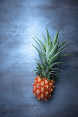 fresh pineapple on gray stone, seen from above, free space for edits