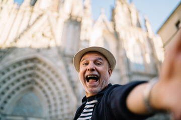 Selfie photo of smiling emotional tourist with open mouth shooting influence travel vlog on...