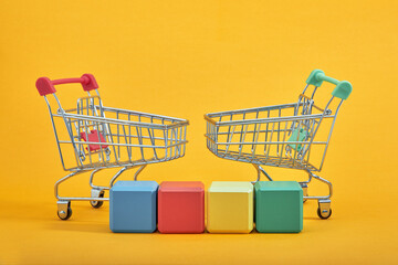 empty wooden cubes mockup style, copy space with shopping trolleys on yellow background. Colourful blocks template for creative design, place for text