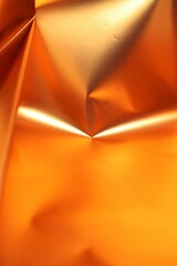 A orange or golden color texture background made by a wrapping paper close up shot