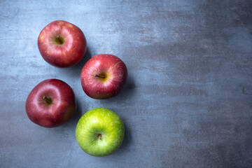 red and green apples on a gray stone background. View from the top. Free space