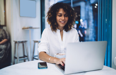 Happy Caucaisan freelancer in smart casual clothing using laptop technology for searching web...