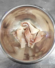 Fresh raw fish fillets are in a metal bowl. Saltwater fish contain a lot of Omega 3.
