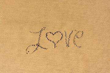 Love written in the sand on a beach