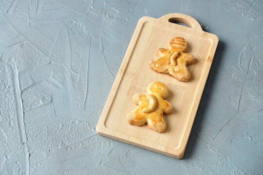 Tasty Homemade Christmas Cookies, Freshly Baked Cashew Nut Biscuits In The Shape Of A Doll On Gray Table 