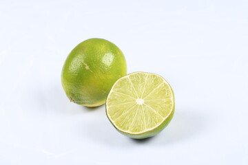 Sliced, bright green lime on a high-key background.