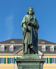 Obraz premium statue of famous composer Ludwig van Beethoven - with the beautiful Old Post Office building in the background, located on Munsterplatz in the city of Bonn in Germany.