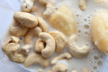 Superfood, vegan ingredients photographed on a high-key background, include bananas, blueberries, kale, soy milk, flaxseed milk, peanut butter, pumpkin seeds and salt.