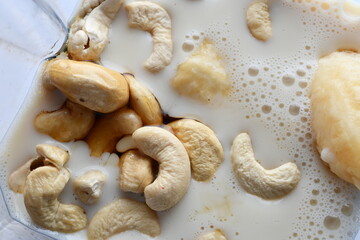 Superfood, vegan ingredients photographed on a high-key background, include bananas, blueberries, kale, soy milk, flaxseed milk, peanut butter, pumpkin seeds and salt.