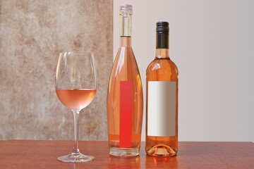 Two different kind of bottles of Rose wine and one glass