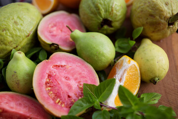 sliced and whole guava and tangerine fruits with Basil leaves