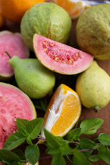 sliced and whole guava and tangerine fruits with Basil leaves