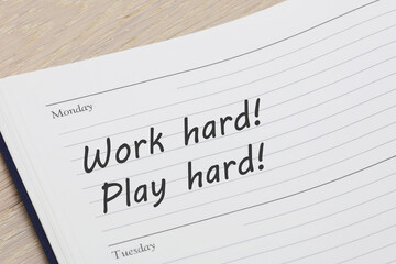 Work hard play hard reminder note in a diary page