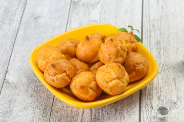 Sweet tasty profiteroles heap in the bowl