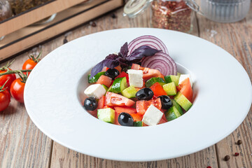 plate with Mediterranean Cucumber Salad on wooden background, close view 